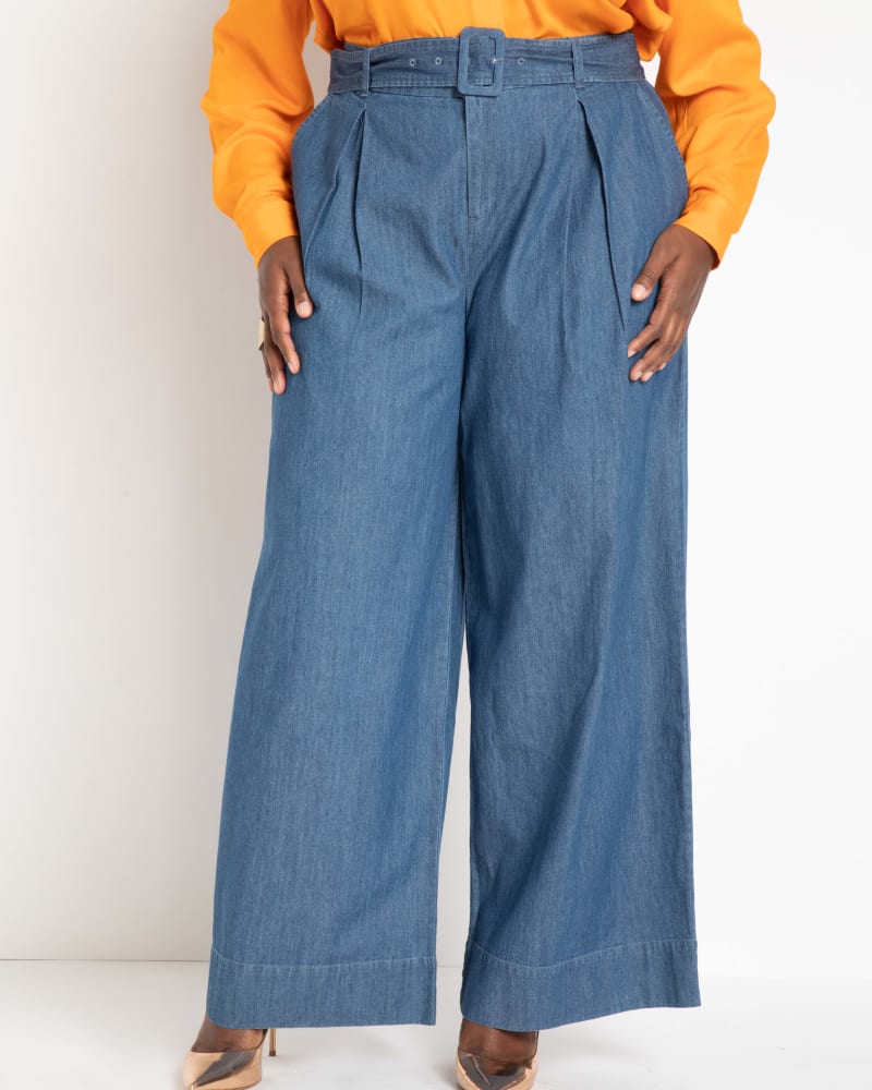 Front of a model wearing a size 16 Belted Pleated Wide Leg Pant in Light Wash by ELOQUII. | dia_product_style_image_id:290185